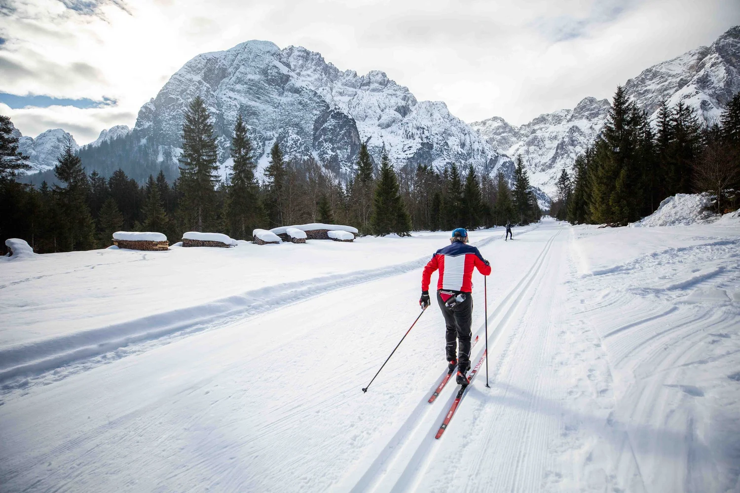 A skier beneath the snow-covered Julian Alps on a Lumi Experiences trip